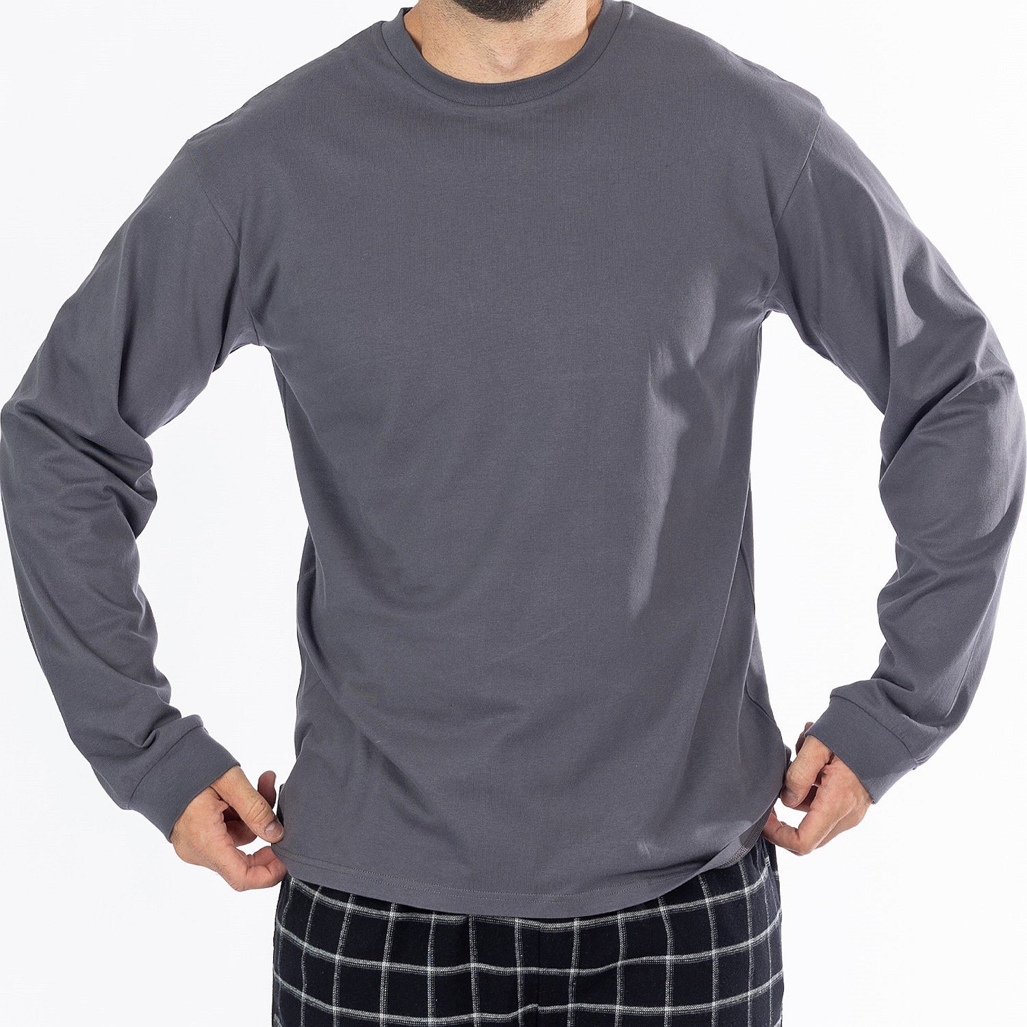 Close up of man wearing a dark grey long sleeve top with black check flannelette pyjama pants.