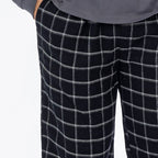 Close up of man wearing black check flannelette pyjama pants.