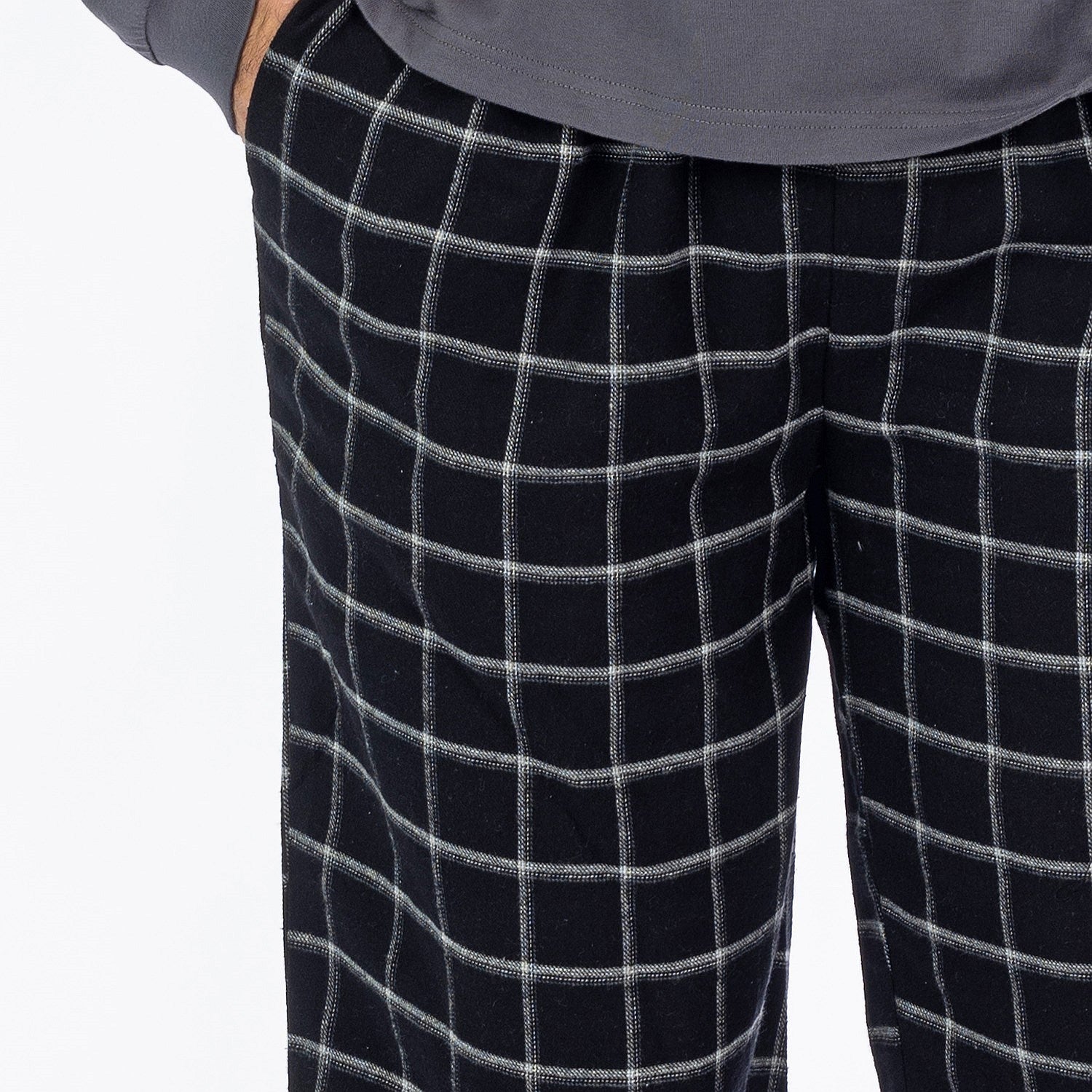 Close up of man wearing black check flannelette pyjama pants.