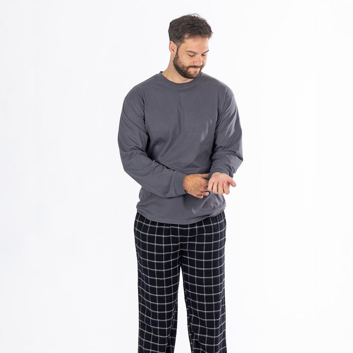 Man wearing a dark grey long sleeve top with black check flannelette pyjama pants.