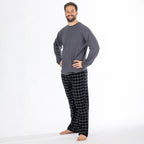 Man wearing a dark grey long sleeve top with black check flannelette pyjama pants.