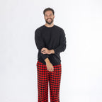 Man wearing a black long sleeve top with red and black check flannelette pyjama pants.
