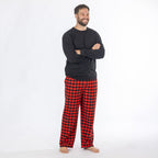 Man wearing a black long sleeve top with red and black check flannelette pyjama pants.