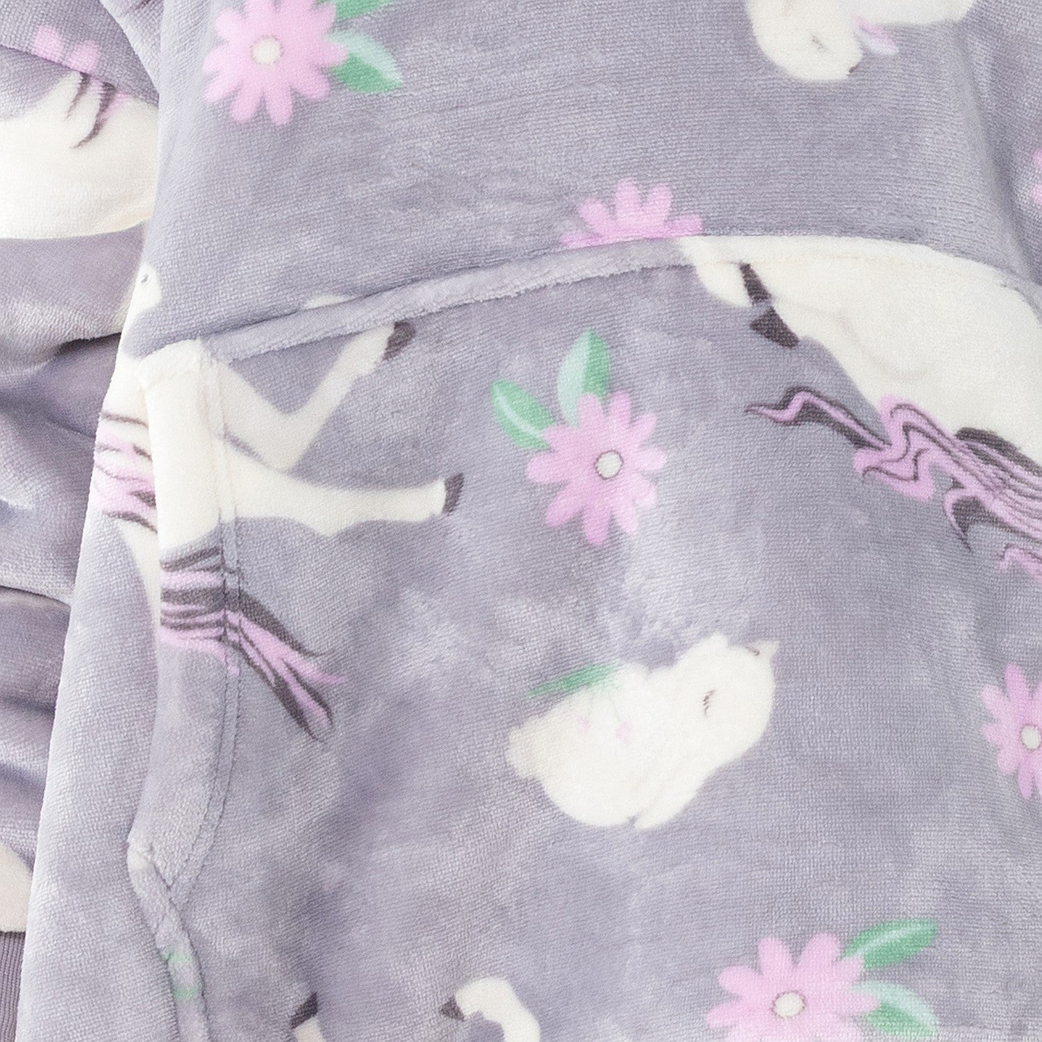 Child wearing a purple unicorn print hooded towel