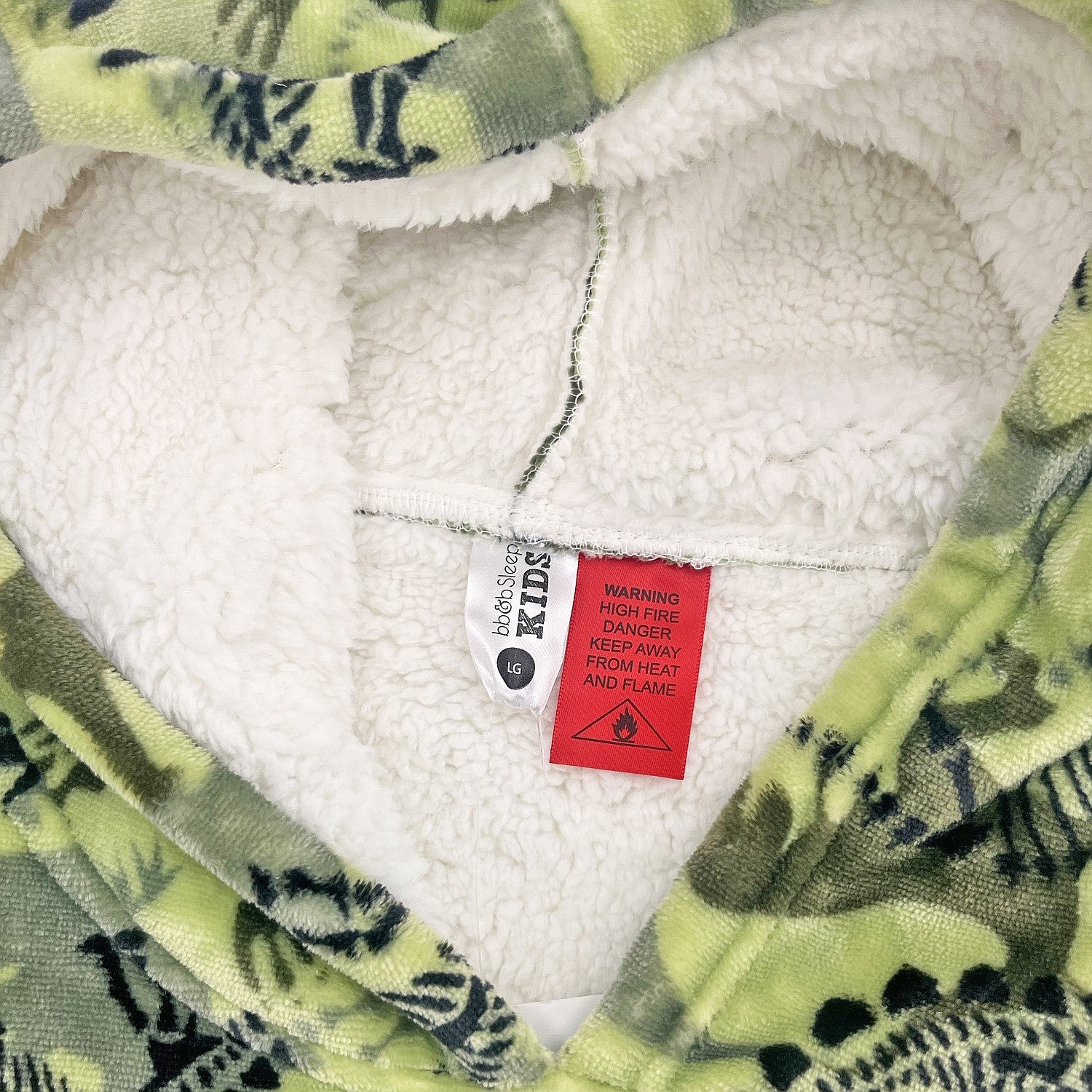 Green dinosaur print hooded towel close-up showing soft sherpa lining.