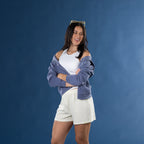 Model wearing yellow striped lounge shorts with a white ribbed tank top and blue zip hoodie.