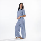 Model wearing faded blue striped lounge pants with a matching striped tee in a side pose.