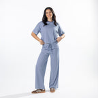 Model wearing faded blue striped lounge pants with a matching striped tee.