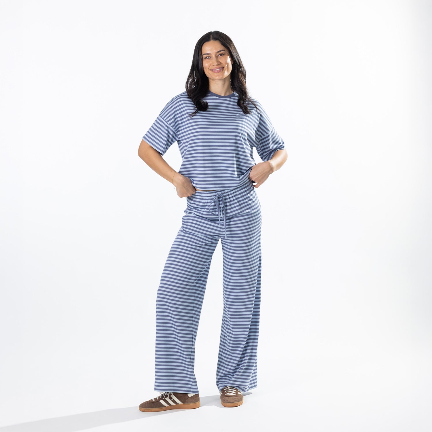 Model wearing faded blue striped lounge pants with a matching striped tee.