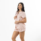 Side-angle view of a woman wearing the pink printed satin pyjama set.