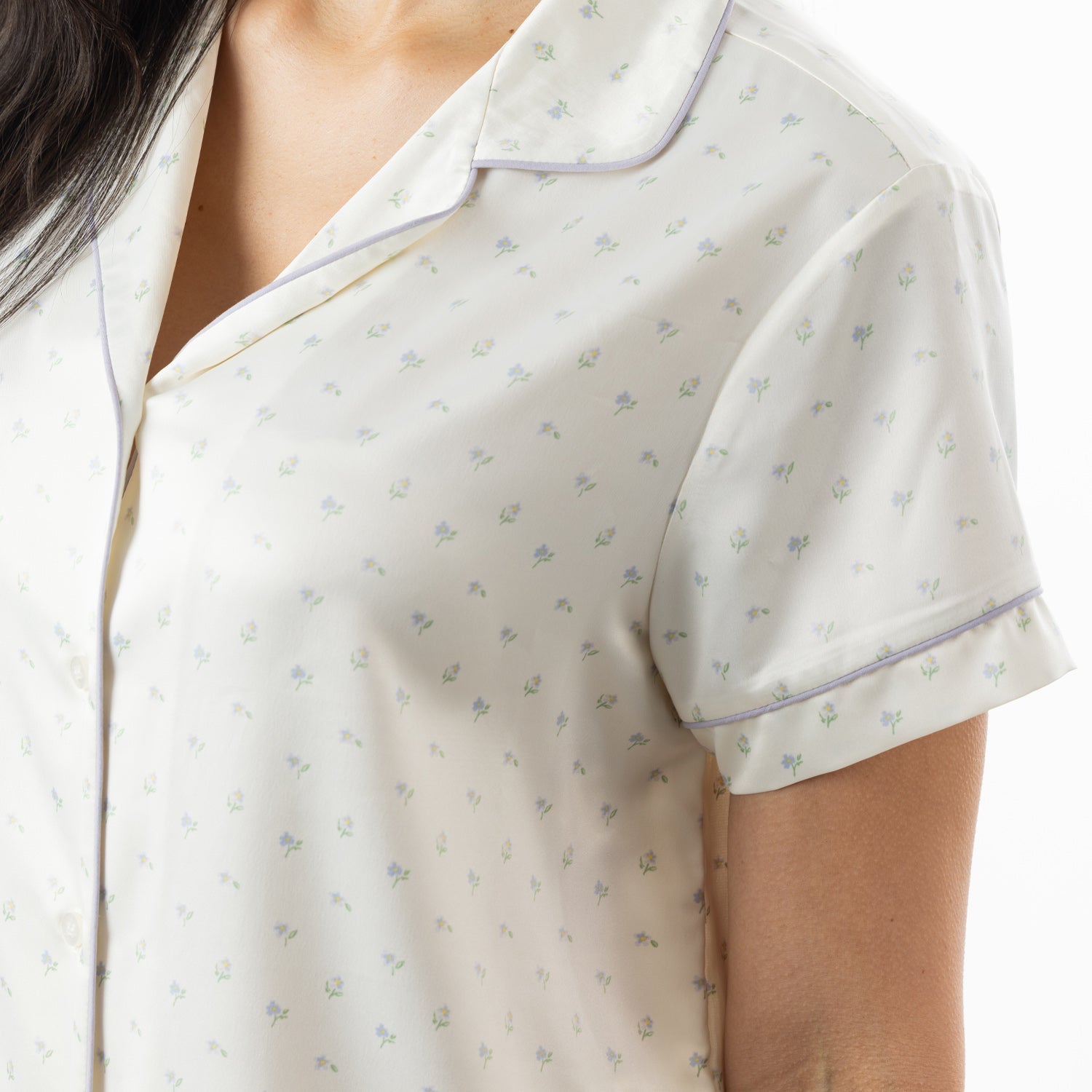 Close-up of the ivory pyjama top, highlighting the delicate floral print, revere collar and contrast piping.