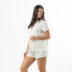 Side-angle view of the ivory floral satin pyjama set, showing the relaxed fit and matching shorts.