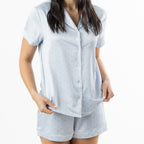 Mid-length view of the pale blue satin pyjama set, showing the button-front top and coordinating shorts.