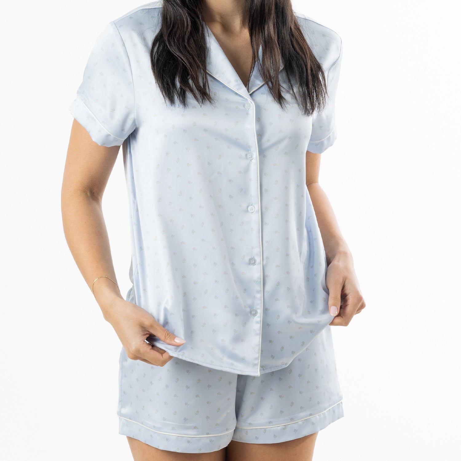 Mid-length view of the pale blue satin pyjama set, showing the button-front top and coordinating shorts.