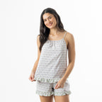 Woman modelling the pink patterned cami pyjama set with thin shoulder straps, matching shorts and contrast frill trim.