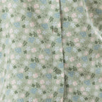 Close-up of the sage fabric, highlighting the delicate all-over floral print and button detail.