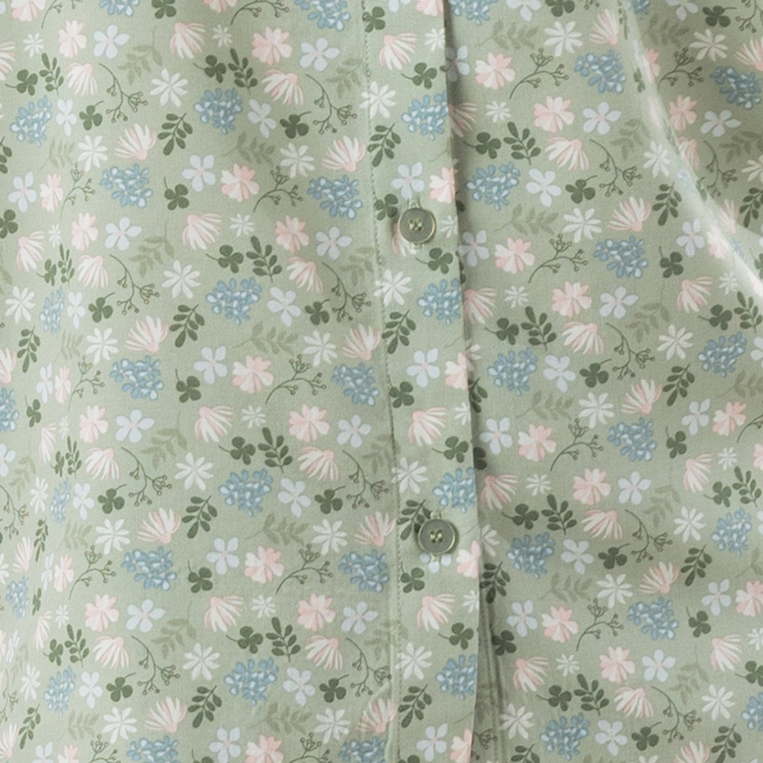 Close-up of the sage fabric, highlighting the delicate all-over floral print and button detail.