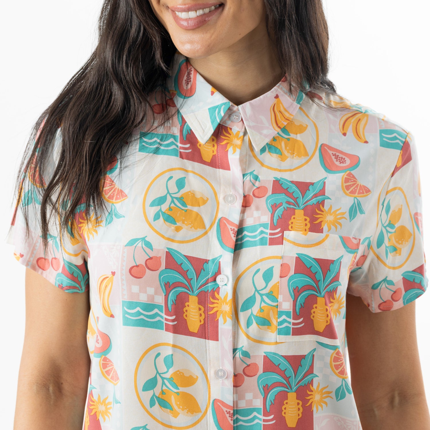 Close-up of the button-up pyjama shirt, highlighting the collar, chest pocket and vibrant fruit print.