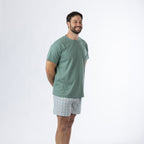 Design Plus Men’s Check PJ Set Blue, shown on a model in a relaxed side pose wearing the sage green T-shirt and blue check shorts.