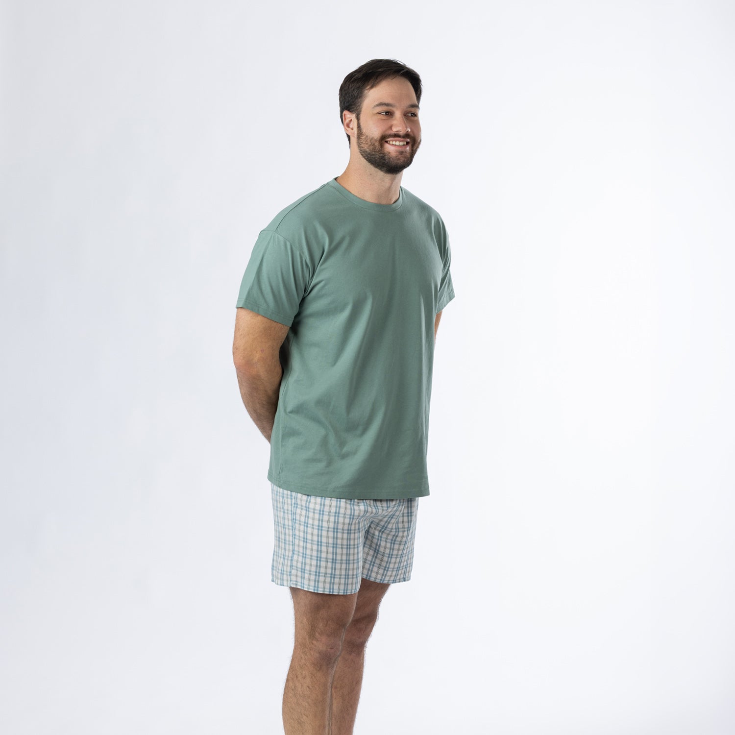 Design Plus Men’s Check PJ Set Blue, shown on a model in a relaxed side pose wearing the sage green T-shirt and blue check shorts.