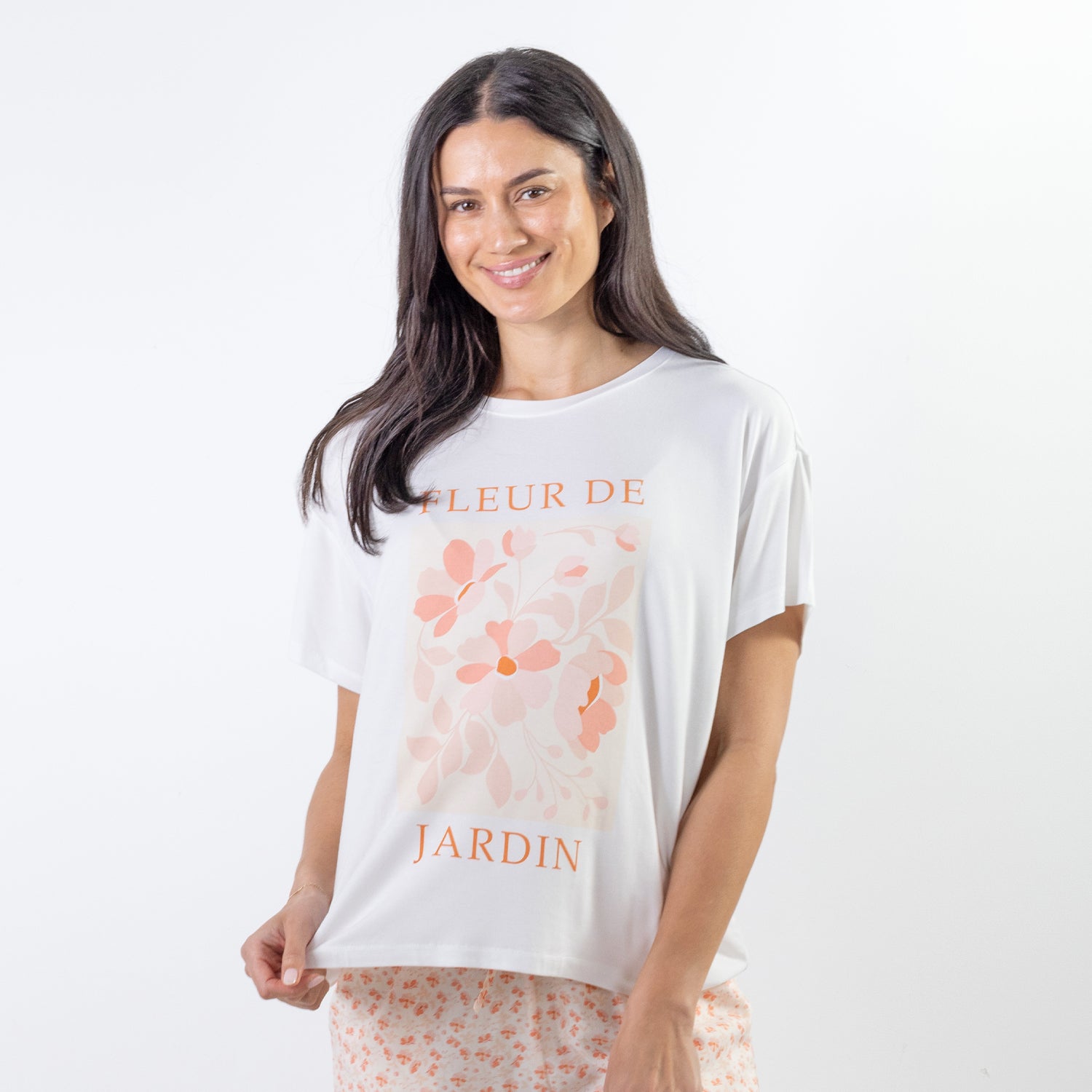 A relaxed-fit white sleep tee features a soft blush floral graphic with elegant typography, creating a fresh and feminine look perfect for comfortable lounging and bedtime.