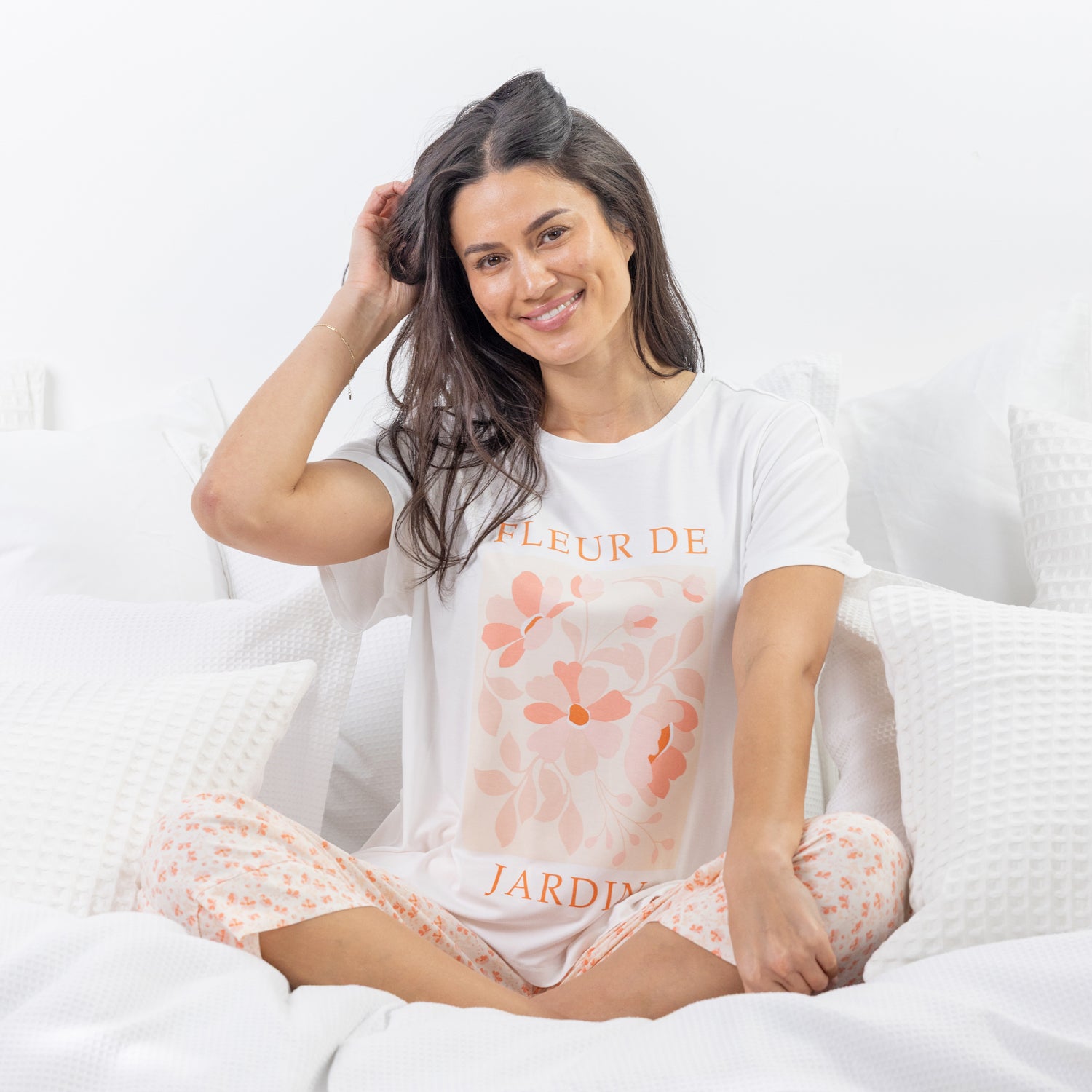 A relaxed-fit white sleep tee features a soft blush floral graphic with elegant typography, creating a fresh and feminine look perfect for comfortable lounging and bedtime.