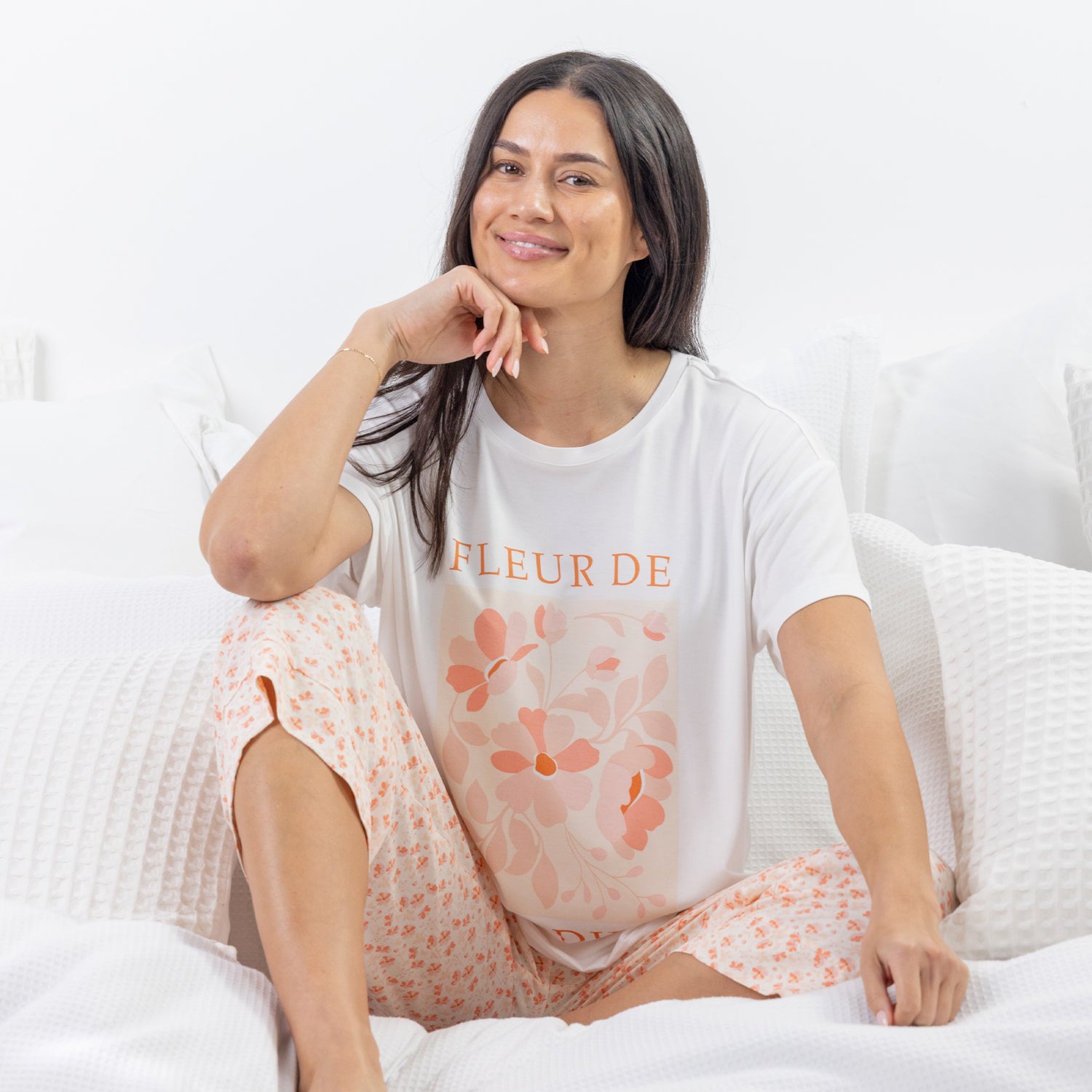 A relaxed-fit white sleep tee features a soft blush floral graphic with elegant typography, creating a fresh and feminine look perfect for comfortable lounging and bedtime.