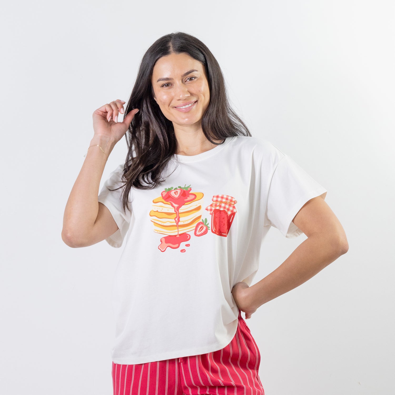 A relaxed-fit white sleep tee features a playful pancake and strawberry jam graphic, adding a fun, feel-good touch to cosy nights and lazy mornings.