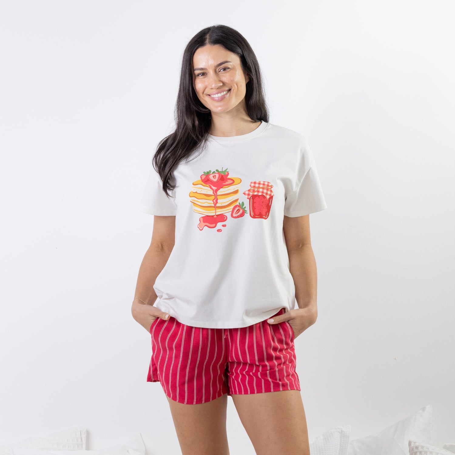 A relaxed-fit white sleep tee features a playful pancake and strawberry jam graphic, adding a fun, feel-good touch to cosy nights and lazy mornings.