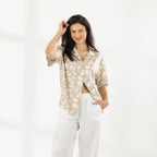 Model wearing the Cove Breeze Shirt in Natural with white relaxed-fit pants against a white studio background.