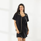 Model wearing the Cove Breeze Stitch Shirt in Black open over a black slip dress, showing the contrast stitch detailing.