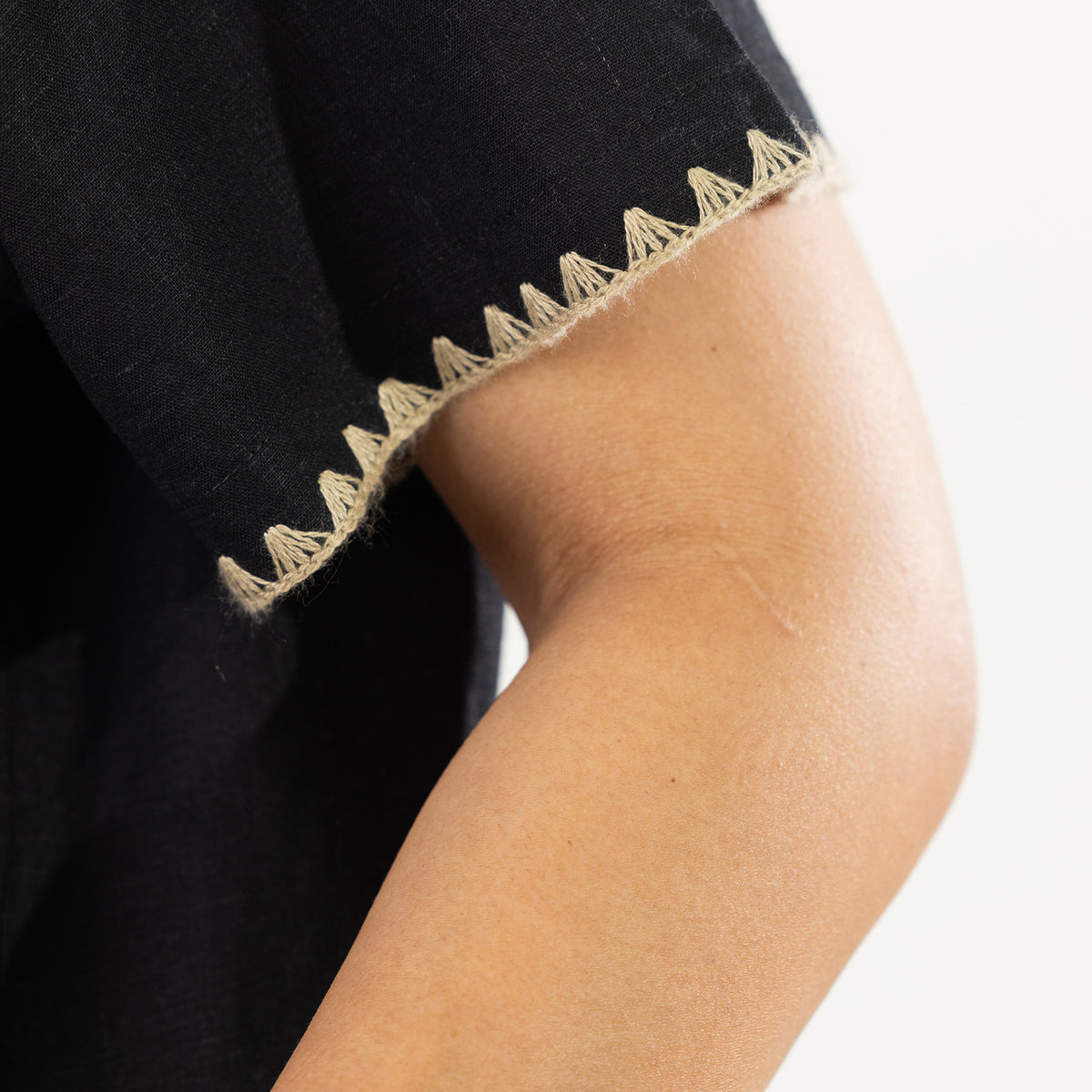 Close-up of the Cove Breeze Stitch Shirt in Black showing the contrast stitch detail along the sleeve edge.