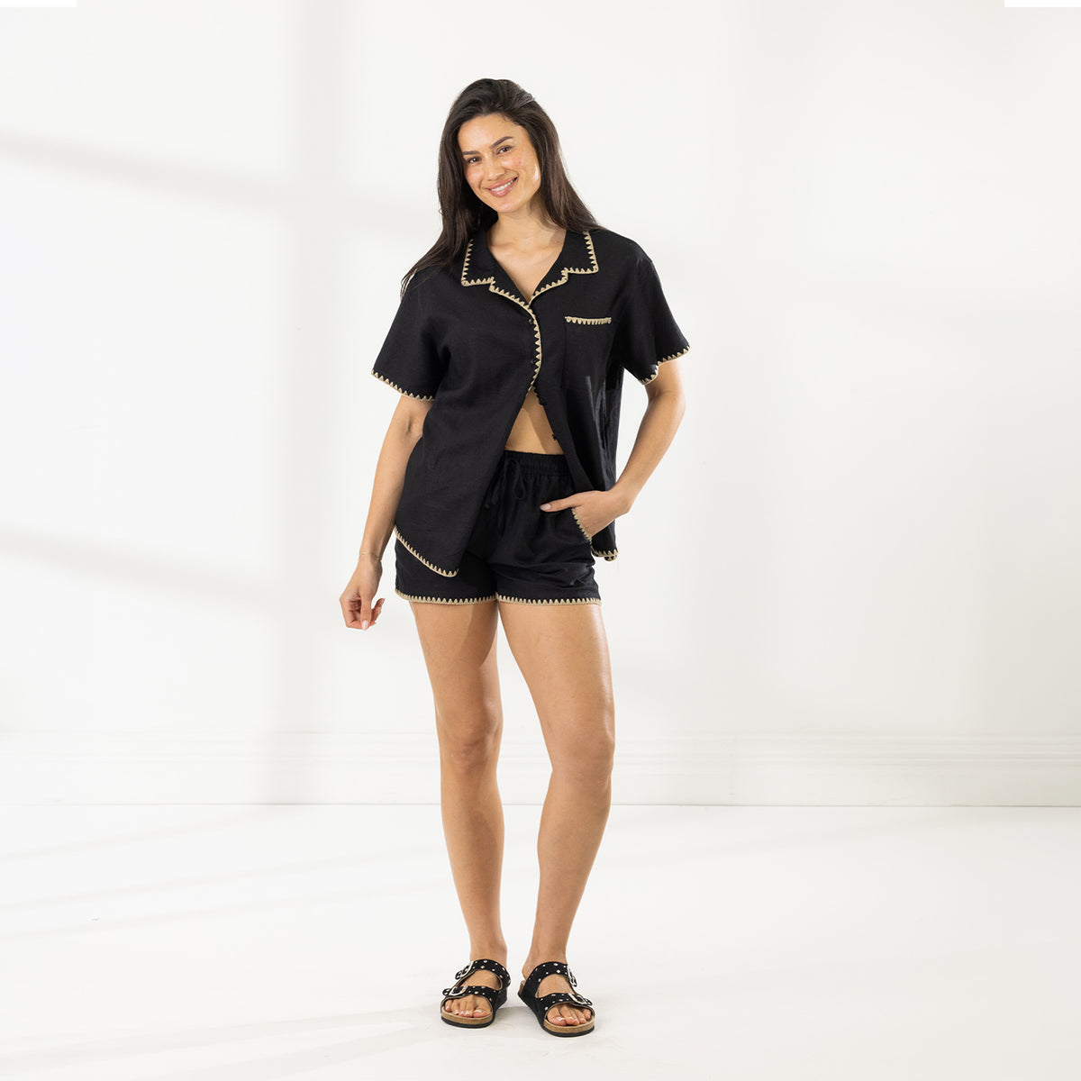 Close-up of the Cove Breeze Stitch Shorts in Black, showing the side pocket and contrast beige stitching along the hems.