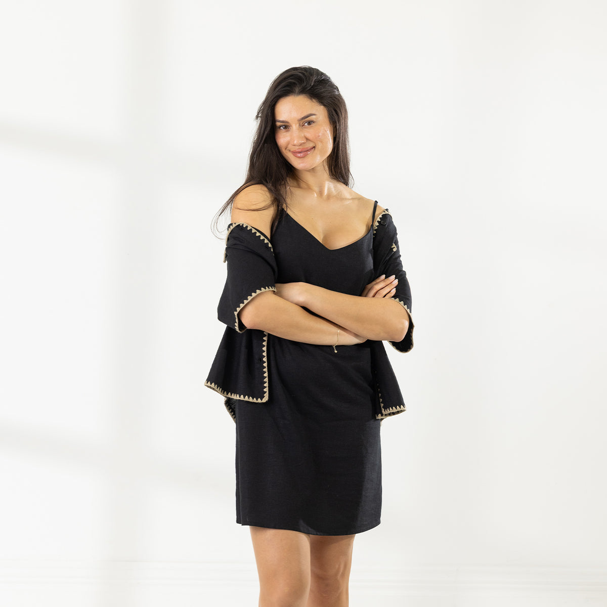 Model wearing the Cove Stitch Slip Dress in Black layered with a black contrast-stitch cover-up.