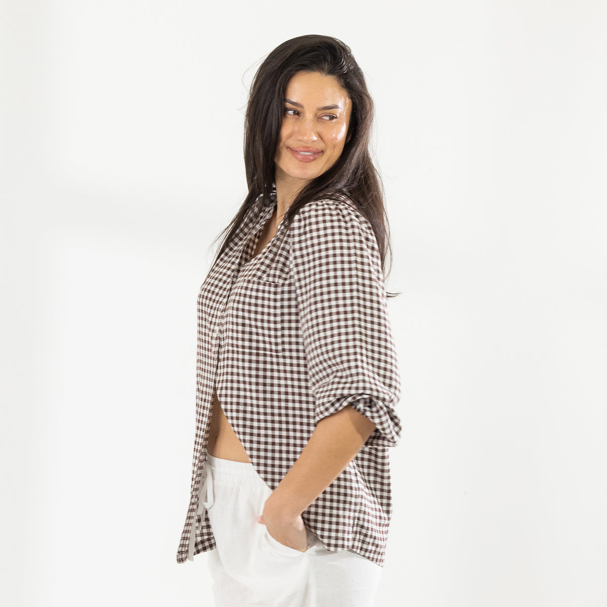 Side view of the model wearing the Cove Breeze Collarless Shirt in Chocolate Check with ivory pants, showing the relaxed fit.