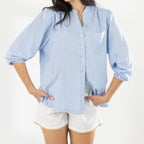 Close-up of the Cove Breeze Collarless Shirt in Chambray, showing the button front, chest pocket and three-quarter sleeves with elasticated cuffs.