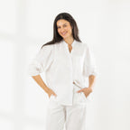 Front view of the model wearing the Cove Breeze Collarless Shirt in Ivory with coordinating ivory pants, showing the button front, chest pocket and three-quarter sleeves.