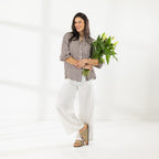 Full-length view of the Cove Breeze Wide Leg Pants in Ivory, styled with a chocolate gingham shirt and sandals.