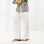 Side view of the Cove Breeze Wide Leg Pants in Ivory, showing the lightweight fabric and relaxed wide-leg silhouette.