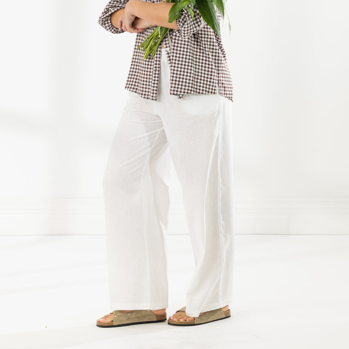 Side view of the Cove Breeze Wide Leg Pants in Ivory, showing the lightweight fabric and relaxed wide-leg silhouette.