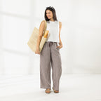 Full-length view of the model wearing the Cove Wide Leg Pants in Chocolate, featuring an all-over gingham check pattern and relaxed wide-leg fit.
