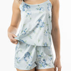 Close-up of the pale blue satin floral cami top and matching shorts, highlighting the blue rose print and smooth fabric finish.