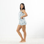 Side view of a woman wearing the pale blue floral satin cami pyjama set with matching shorts.