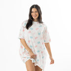 Woman modelling an ivory oversized sleep tee with an all-over pink and blue macaroon print and short sleeves.