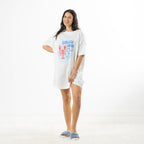 Full-length view of the white Lobster Lovers Club oversized sleep tee styled with fluffy blue slippers against a white studio background.