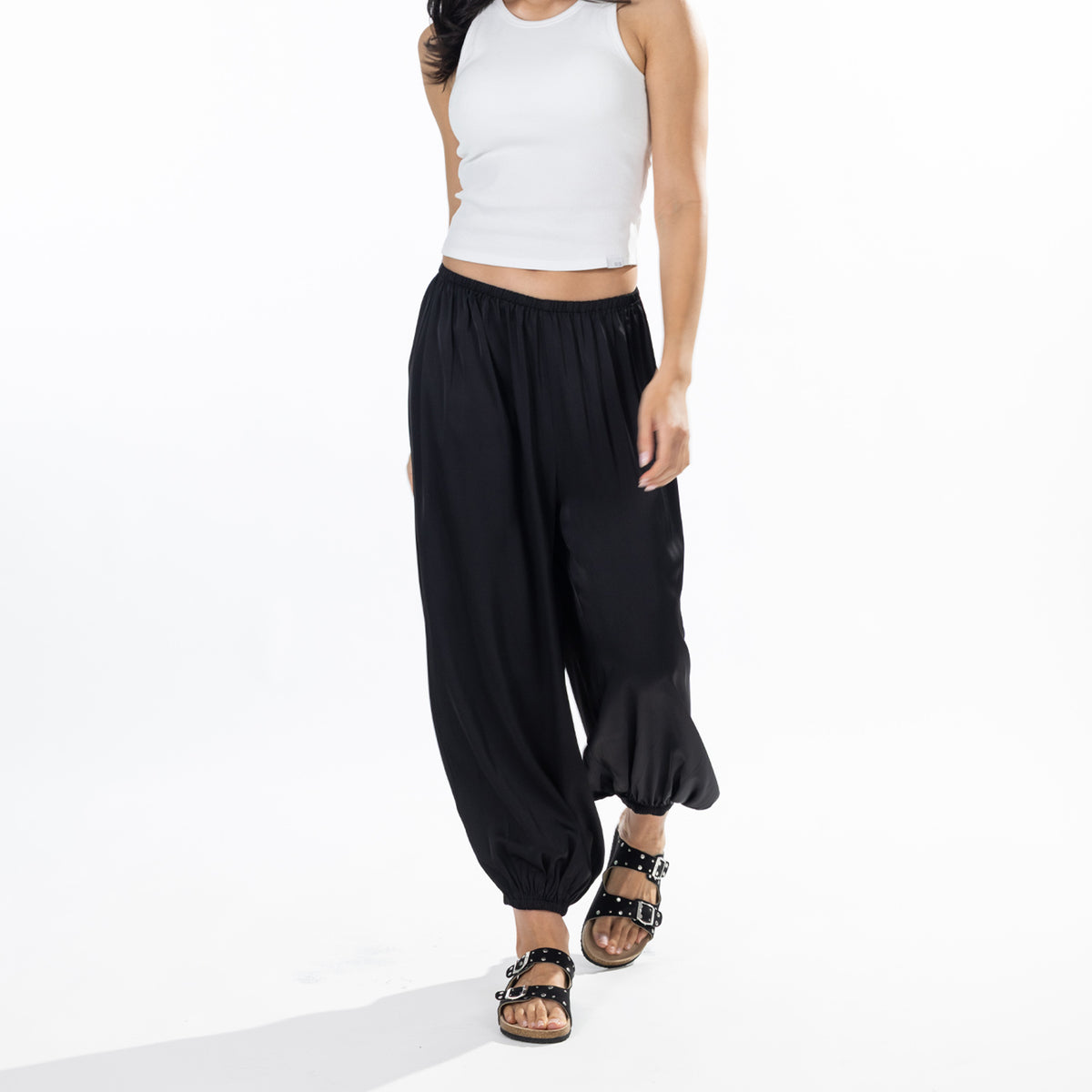 Model wearing black Simple & Sunday Lounge Satin Pants with a relaxed wide-leg fit, elasticated waistband and gathered ankle cuffs.