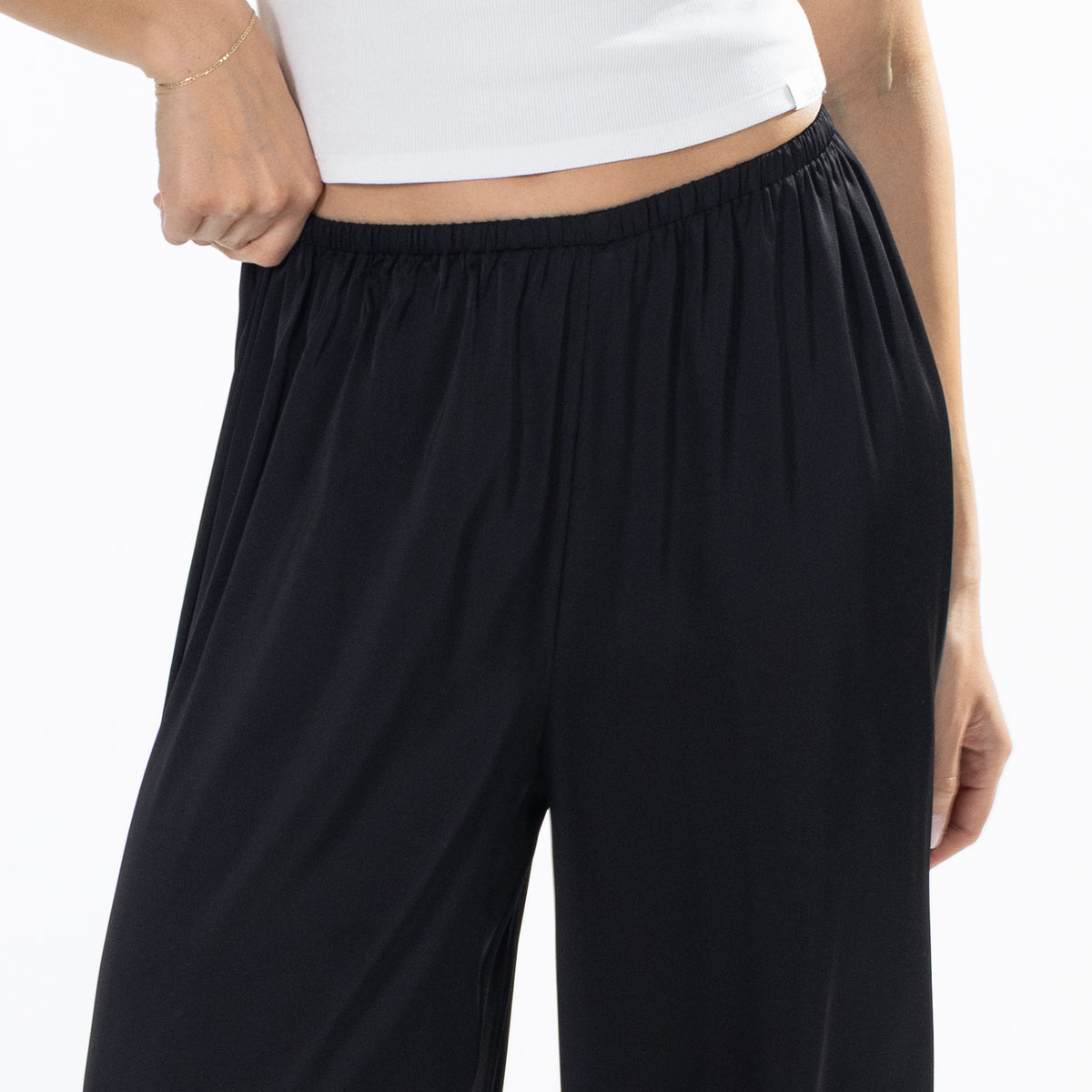 Close-up of black Simple & Sunday Lounge Satin Pants showing the smooth satin fabric and elasticated waistband.