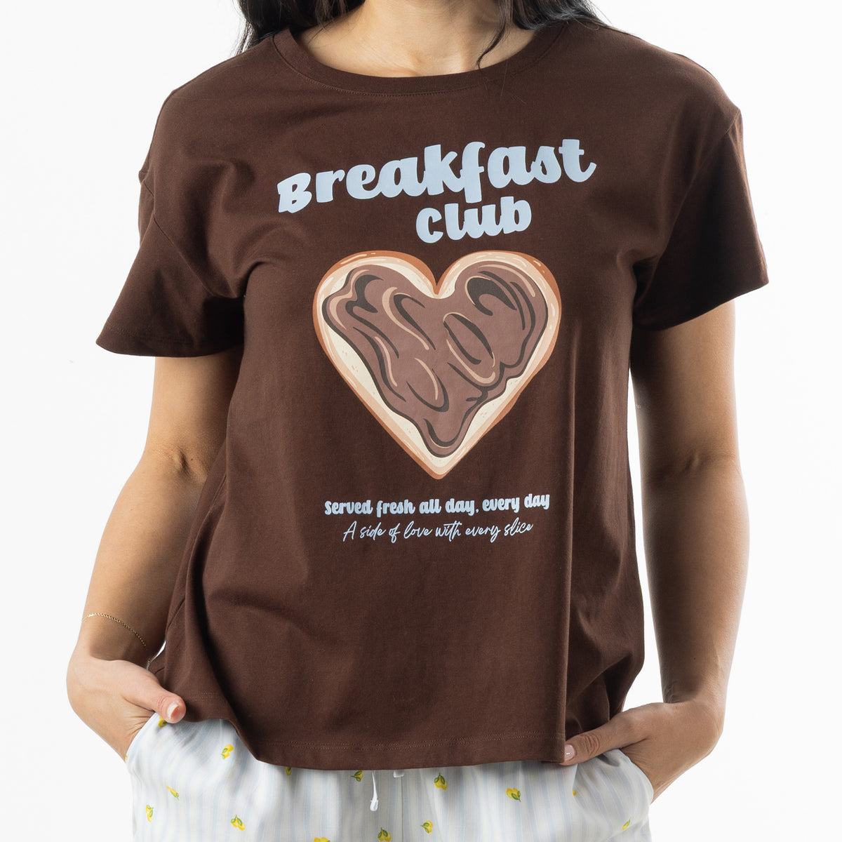 Close-up of the chocolate brown bb&b Sleep Heart Toast Print Sleep Tee showing the Breakfast Club lettering, heart-shaped toast illustration and printed slogan.