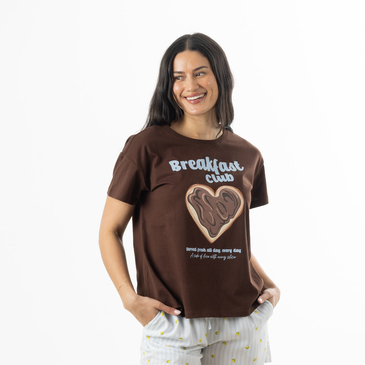 Close-up of a model wearing the chocolate brown bb&b Sleep Heart Toast Print Sleep Tee featuring a heart-shaped toast graphic and short sleeves.