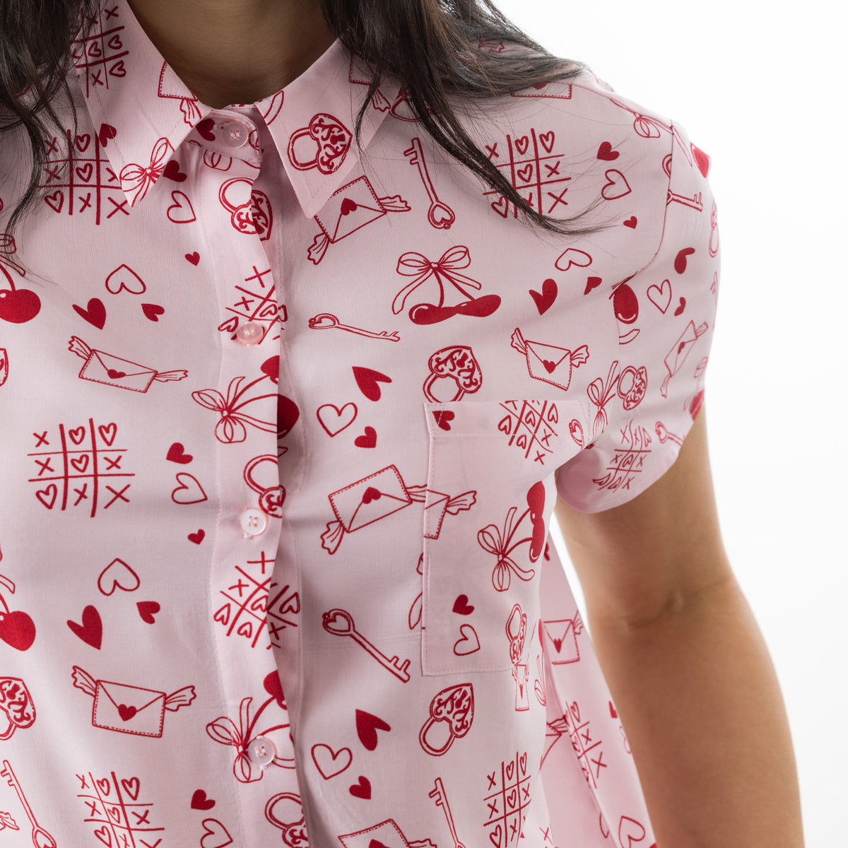 Close-up of the bb&b Sleep XOXO PJ Set in Pink, featuring the collared neckline, chest pocket and playful red love-themed print.